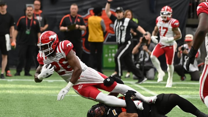 Jun 15, 2024; Vancouver, British Columbia, CAN;  Calgary Stampeders running back Dedrick Mills (26) is tackled by BC Lions player during the second half at BC Place. Mandatory Credit: Simon Fearn-USA TODAY Sports