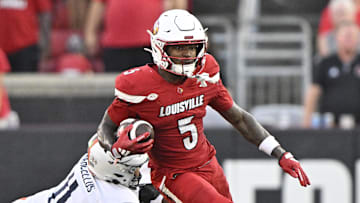Oct 4, 2025; Louisville, Kentucky, USA; Louisville Cardinals wide receiver Caullin Lacy (5) runs the ball against Virginia Cavaliers linebacker Maddox Marcellus (11) during the second half at L&N Federal Credit Union Stadium. Virginia defeated Louisville 30-27. Mandatory Credit: Jamie Rhodes-Imagn Images