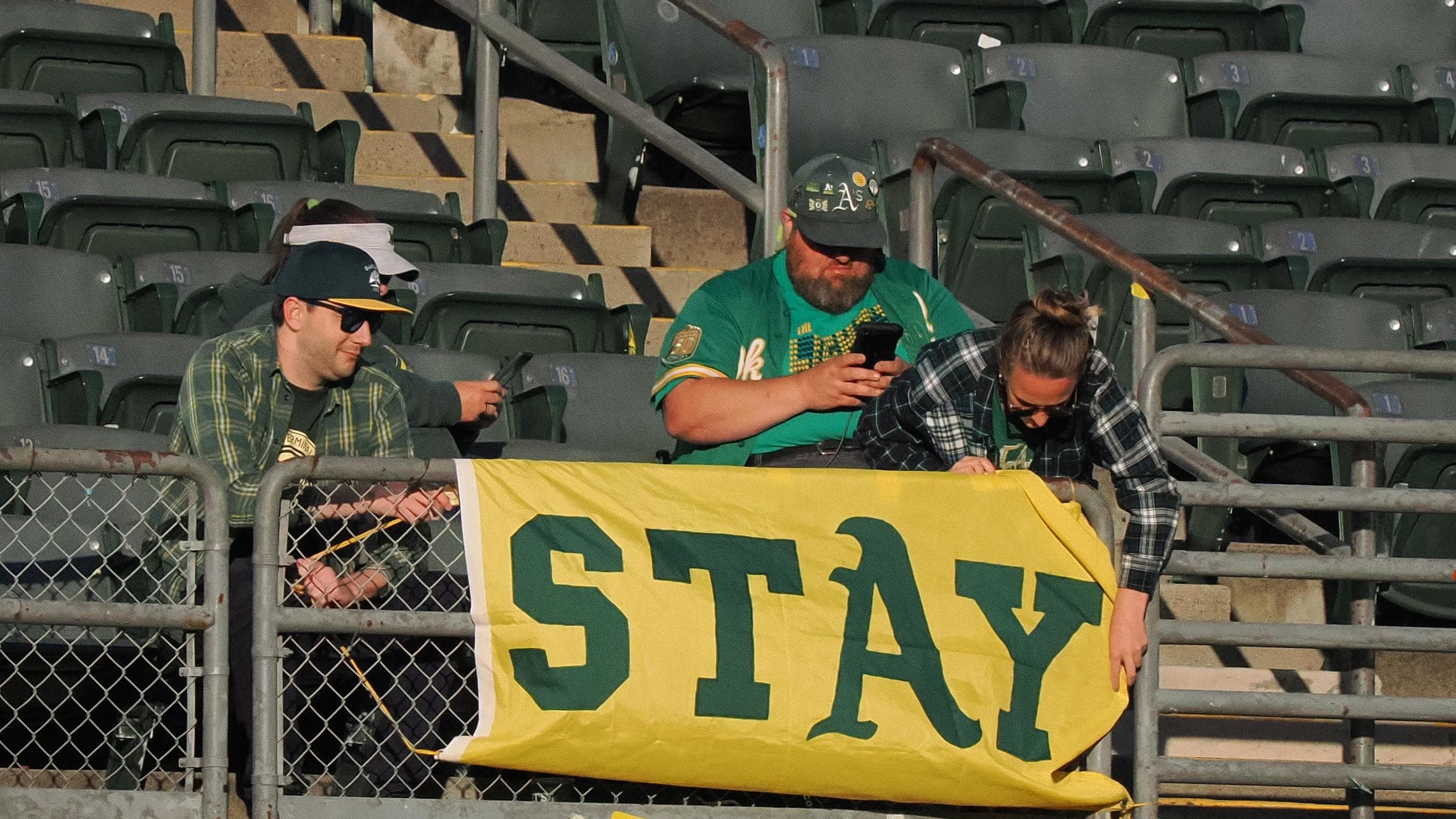 Apr 28, 2023; Oakland, California, USA; Oakland Athletics fans put up a flag reading 