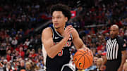 Nov 14, 2025; Inglewood, California, USA;  Arizona Wildcats guard Brayden Burries (5) drives to the basket against UCLA Bruins center Xavier Booker (1) during the first half of the Hall of Fame Series game at Intuit Dome. Mandatory Credit: Kiyoshi Mio-Imagn Images