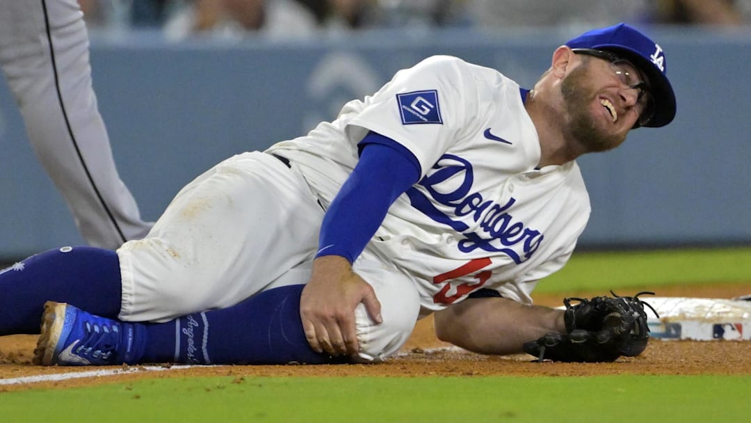 Los Angeles Dodgers third baseman Max Muncy (13) grabs his knee