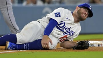 Los Angeles Dodgers third baseman Max Muncy (13) grabs his knee