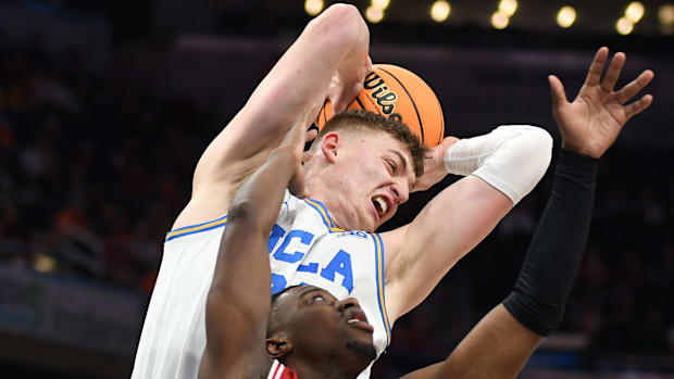 UCLA forward Tyler Bilodeau rebounds the ball over Wisconsin guard John Blackwell.