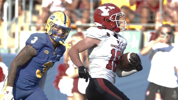 Sep 21, 2024; Pittsburgh, Pennsylvania, USA;  Youngstown State Penguins wide receiver Cyrus Traugh (18) runs for a touchdown against Pittsburgh Panthers defensive back Donovan McMillon (3) during the second quarter at Acrisure Stadium. Mandatory Credit: Charles LeClaire-Imagn Images