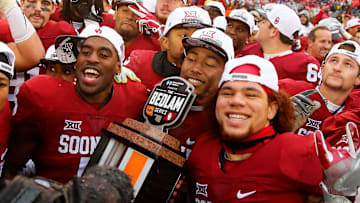 Dec 3, 2016; Norman, OK, USA;  Oklahoma Sooners players celebrate with the Bedlam series trophy after the game against the Oklahoma State Cowboys at Gaylord Family - Oklahoma Memorial Stadium. Mandatory Credit: Kevin Jairaj-Imagn Images