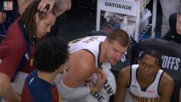 Nikola Jokic reacts to the Nuggets blowout loss on the bench.
