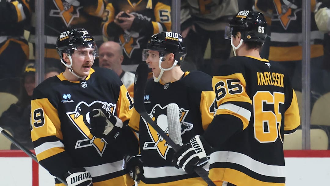 Mar 13, 2025; Pittsburgh, Pennsylvania, USA;  Pittsburgh Penguins center Connor Dewar (19) celebrates his goal with center Blake Lizotte (middle) and defenseman Erik Karlsson (65) against the St. Louis Blues during the second period at PPG Paints Arena. Mandatory Credit: Charles LeClaire-Imagn Images