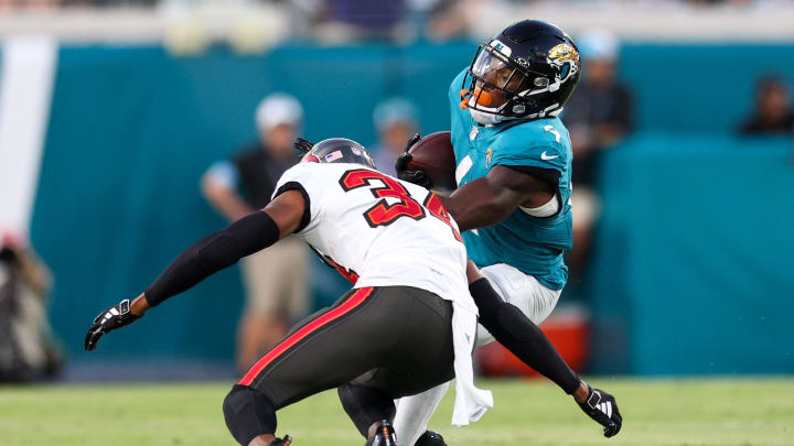 Aug 17, 2024; Jacksonville, Florida, USA; Jacksonville Jaguars running back Tank Bigsby (4) is tackled by Tampa Bay Buccaneers cornerback Bryce Hall (34) in the first quarter during a preseason game at EverBank Stadium. Mandatory Credit: Nathan Ray Seebeck-USA TODAY Sports