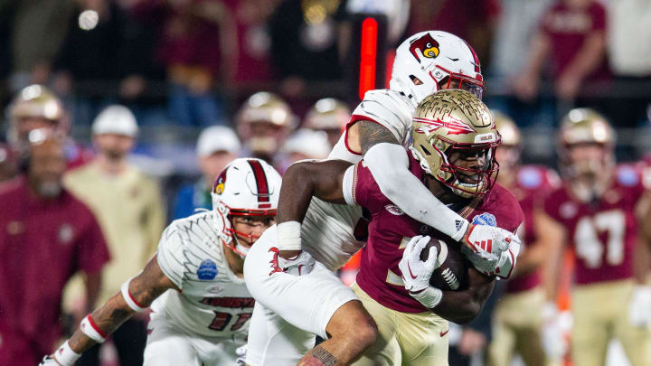 Florida State Seminoles running back Trey Benson (3) gets tackled from behind as he runs down the field. The Florida State Seminoles defeated the Louisville Cardinals 16-6 to claim the ACC Championship title in Charlotte, North Carolina on Saturday, Dec. 2, 2023.