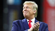 United States President Donald J. Trump smiles while on the field for the national anthem before the College Football Playoff national championship game between the Clemson Tigers and the LSU Tigers at Mercedes-Benz Superdome. Mandatory Credit: Matthew Emmons-Imagn Images