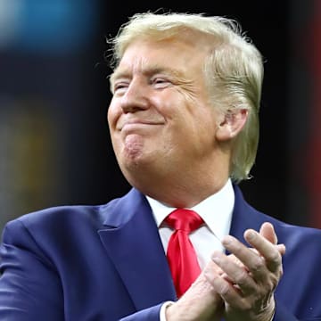 United States President Donald J. Trump smiles while on the field for the national anthem before the College Football Playoff national championship game between the Clemson Tigers and the LSU Tigers at Mercedes-Benz Superdome. Mandatory Credit: Matthew Emmons-Imagn Images