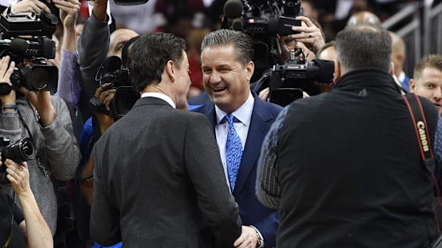 Former Kentucky coach John Calipari and former Louisville coach Rick Pitino greet each othe