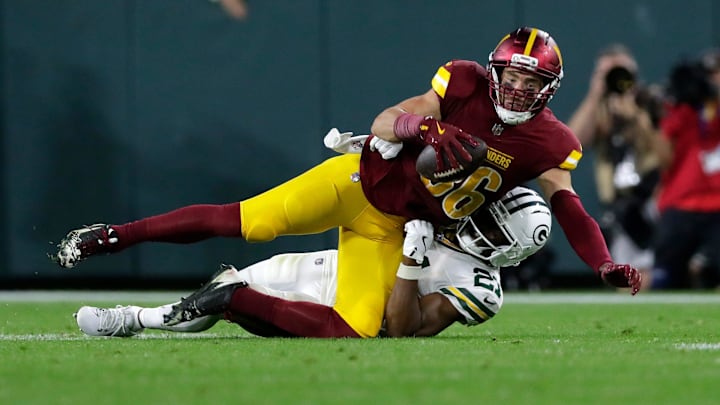 Washington Commanders tight end Zach Ertz is tackled by Green Bay Packers cornerback Nate Hobbs.