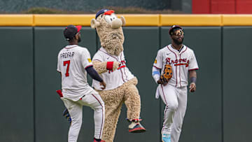 Aug 9, 2025; Cumberland, Georgia, USA; Atlanta Braves left fielder Jurickson Profar (7) team mascot Blooper and center fielder Michael Harris II react after the Braves defeated the Miami Marlins at Truist Park. Mandatory Credit: Dale Zanine-Imagn Images