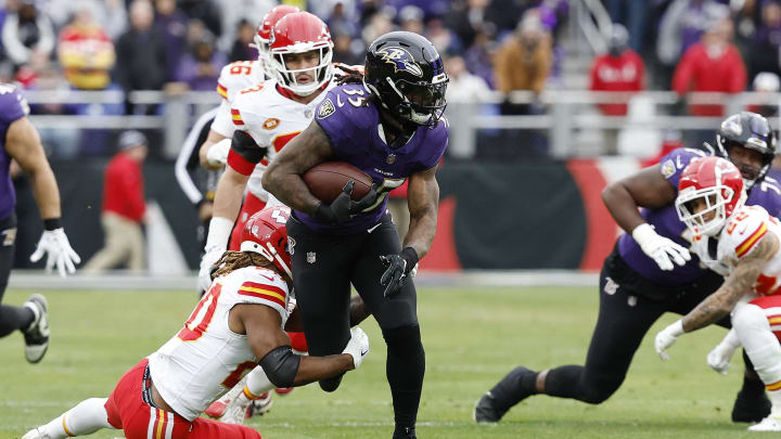 Jan 28, 2024; Baltimore, Maryland, USA; Baltimore Ravens running back Gus Edwards (35) runs with the ball as Kansas City Chiefs safety Justin Reid (20) defends during the first half in the AFC Championship football game at M&T Bank Stadium. Mandatory Credit: Geoff Burke-USA TODAY Sports