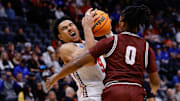 Mar 20, 2025; Denver, CO, USA; Montana Grizzlies guard Money Williams (0) defends against Wisconsin Badgers guard John Tonje (9) during the first half in the first round of the NCAA Tournament at Ball Arena.