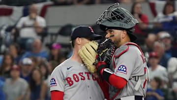 Mar 29, 2025; Arlington, Texas, USA; Boston Red Sox starting pitcher Walker Buehler (0) is visited on the mound by catcher Carlos Narvaez (75) during the first inning against the Texas Rangers at Globe Life Field. Mandatory Credit: Raymond Carlin III-Imagn Images