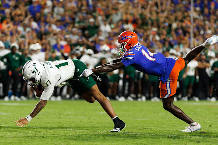 South Florida Bulls quarterback Byrum Brown rushes with the ball past Florida Gators defensive back Jordan Castell. 