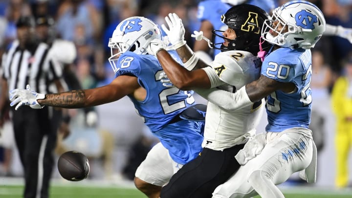 Sep 9, 2023; Chapel Hill, North Carolina, USA; North Carolina Tar Heels defensive backs Alijah Huzzie (28) and Tayon Holloway (20) break up a pass intended for Appalachian State Mountaineers wide receiver Kaedin Robinson (2) in the fourth quarter at Kenan Memorial Stadium. Mandatory Credit: Bob Donnan-USA TODAY Sports