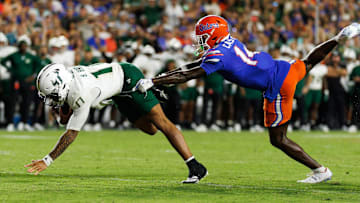Sep 6, 2025; Gainesville, Florida, USA; South Florida Bulls quarterback Byrum Brown (17) rushes with the ball past Florida Gators defensive back Jordan Castell (14) during the second half at Ben Hill Griffin Stadium. Mandatory Credit: Matt Pendleton-Imagn Images