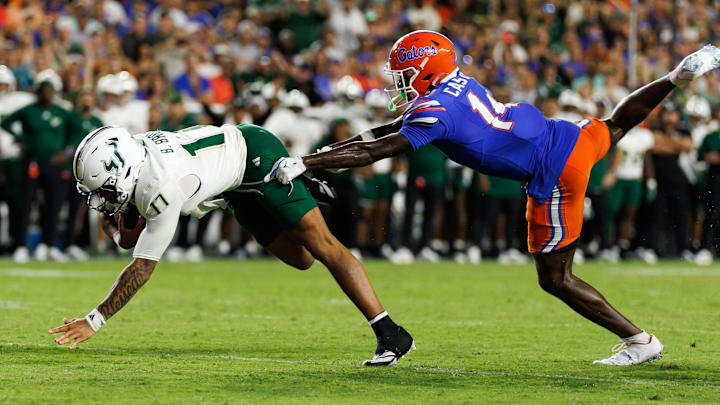 Sep 6, 2025; Gainesville, Florida, USA; South Florida Bulls quarterback Byrum Brown (17) rushes with the ball past Florida Gators defensive back Jordan Castell (14) during the second half at Ben Hill Griffin Stadium. Mandatory Credit: Matt Pendleton-Imagn Images