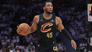 Apr 26, 2025; Miami, Florida, USA; Cleveland Cavaliers guard Donovan Mitchell (45) dribbles the basketball as Miami Heat forward Andrew Wiggins (22) defends in the first quarter during game three for the first round of the 2025 NBA Playoffs at Kaseya Center. Mandatory Credit: Sam Navarro-Imagn Images