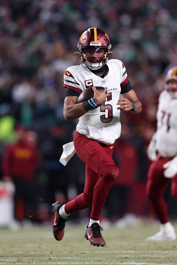 Washington Commanders quarterback Jayden Daniels (5) runs with the ball.