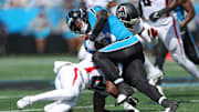 Sep 21, 2025; Charlotte, North Carolina, USA; Carolina Panthers running back Rico Dowdle (5) pushes for yards against Atlanta Falcons cornerback Dee Alford (20) during the first half of a game between Carolina Panthers and the Atlanta Falcons at Bank of America Stadium. 