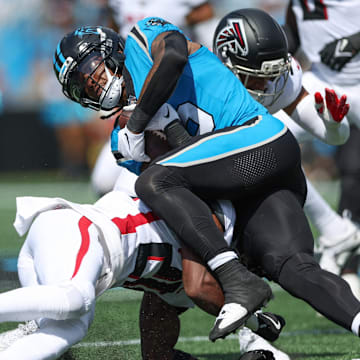 Sep 21, 2025; Charlotte, North Carolina, USA; Carolina Panthers running back Rico Dowdle (5) pushes for yards against Atlanta Falcons cornerback Dee Alford (20) during the first half of a game between Carolina Panthers and the Atlanta Falcons at Bank of America Stadium. 
