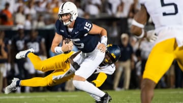 Penn State quarterback Drew Allar slips a sack attempt from West Virginia linebacker Trey Lathan