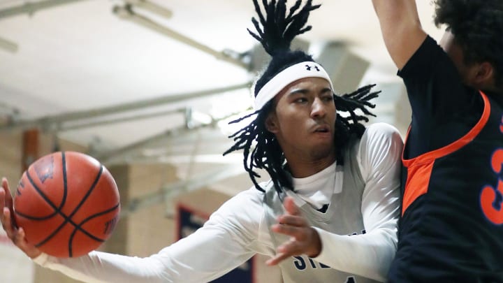 Stepinac’s Boogie Fland (1) passes to a teammate as his path to the basket is blocked by St. Ray’s Colin Phang (33) during CHSAA basketball action at Archbishop Stepinac High School in White Plains Jan. 19, 2024. Stepinac won the game 100-71.