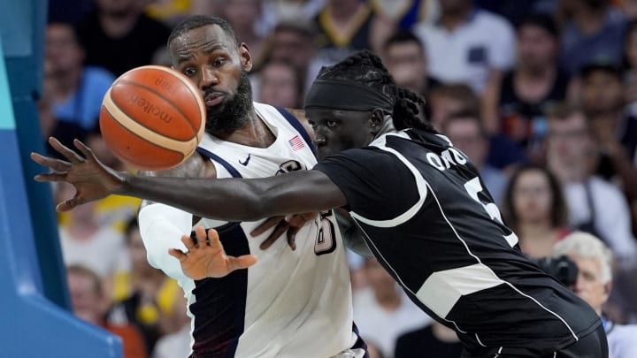 Villeneuve-d'Ascq, France; United States guard Lebron James (6) and South Sudan small forward Nuni Omot (5) fight for a loose ball in the fourth quarter during the Paris 2024 Olympic Summer Games at Stade Pierre-Mauroy. Mandatory Credit: