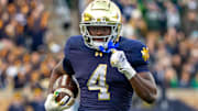Nov 22, 2025; South Bend, Indiana, USA; Notre Dame Fighting Irish running back Jeremiyah Love (4) runs the ball against the Syracuse Orange during the first half at Notre Dame Stadium. 