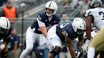 Penn State football quarterback Drew Allar lines up behind center Nick Dawkins 