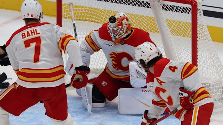 Oct 15, 2025; Salt Lake City, Utah, USA; Calgary Flames goaltender Devin Cooley (1) blocks a shot by the Utah Mammoth during the second period at Delta Center. Mandatory Credit: Rob Gray-Imagn Images
