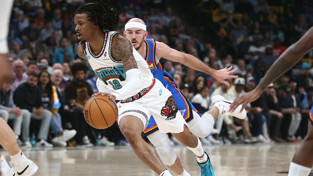 Apr 24, 2025; Memphis, Tennessee, USA; Memphis Grizzlies guard Ja Morant (12) drives to the basket as Oklahoma City Thunder guard Alex Caruso (9) defends during the second quarter during game three for the first round of the 2024 NBA Playoffs at FedExForum. Mandatory Credit: Petre Thomas-Imagn Images