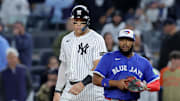Oct 8, 2025; Bronx, New York, USA; New York Yankees right fielder Aaron Judge (99) leads off first base against Toronto Blue Jays first baseman Vladimir Guerrero Jr. (27) during the ninth inning of game four of the ALDS round of the 2025 MLB playoffs at Yankee Stadium. Mandatory Credit: Brad Penner-Imagn Images