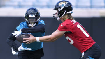 Jacksonville Jaguars quarterback Trevor Lawrence (16) hands off the ball to running back Travis Etienne.