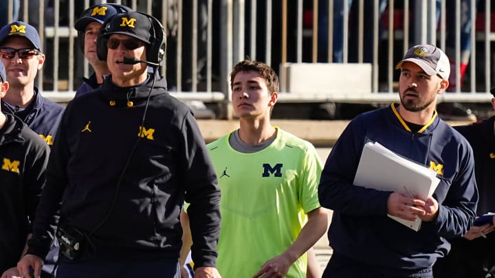 Nov 26, 2022; Columbus, Ohio, USA; Michigan Wolverines head coach Jim Harbaugh watches from the sideline beside off-field analyst Connor Stalions, right, during the NCAA football game against the Ohio State Buckeyes at Ohio Stadium.