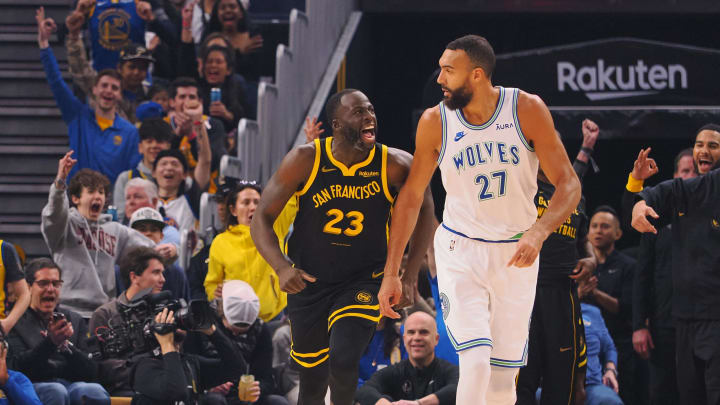 Nov 12, 2023; San Francisco, California, USA; Golden State Warriors forward Draymond Green (23) celebrates behind Minnesota Timberwolves center Rudy Gobert (27) after scoring a three point basket during the first quarter at Chase Center. 