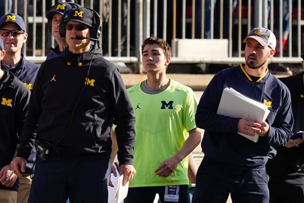 Michigan off-field analyst Connor Stalions watches play between the Wolverines and Ohio State from behind Jim Harbaugh