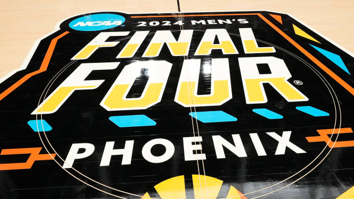 Workers install the 2024 NCAA Men's Final Four Official Court at State Farm Stadium in Glendale on