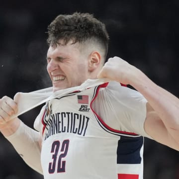 Apr 8, 2024; Glendale, AZ, USA; Connecticut Huskies center Donovan Clingan (32) reacts and rips his undershirt in the second half against the Purdue Boilermakers in the national championship game of the Final Four of the 2024 NCAA Tournament at State Farm Stadium. Mandatory Credit: Robert Deutsch-USA TODAY Sports