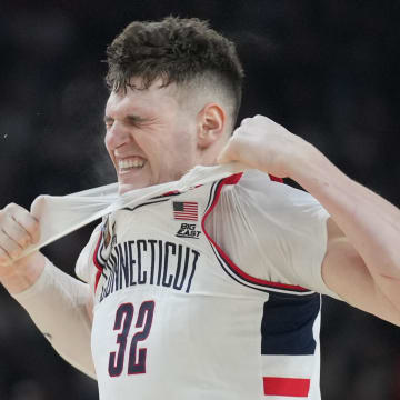 Apr 8, 2024; Glendale, AZ, USA; Connecticut Huskies center Donovan Clingan (32) reacts and rips his undershirt in the second half against the Purdue Boilermakers in the national championship game of the Final Four of the 2024 NCAA Tournament at State Farm Stadium. Mandatory Credit: Robert Deutsch-USA TODAY Sports