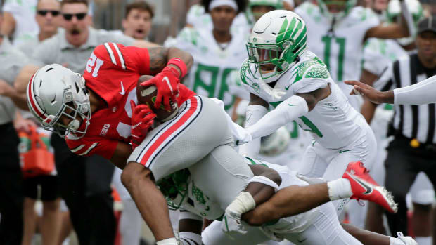 Ohio State Buckeyes wide receiver Emeka Egbuka (12) is tackled by Oregon Ducks safety Verone McKinley III (23) and Oregon Duc