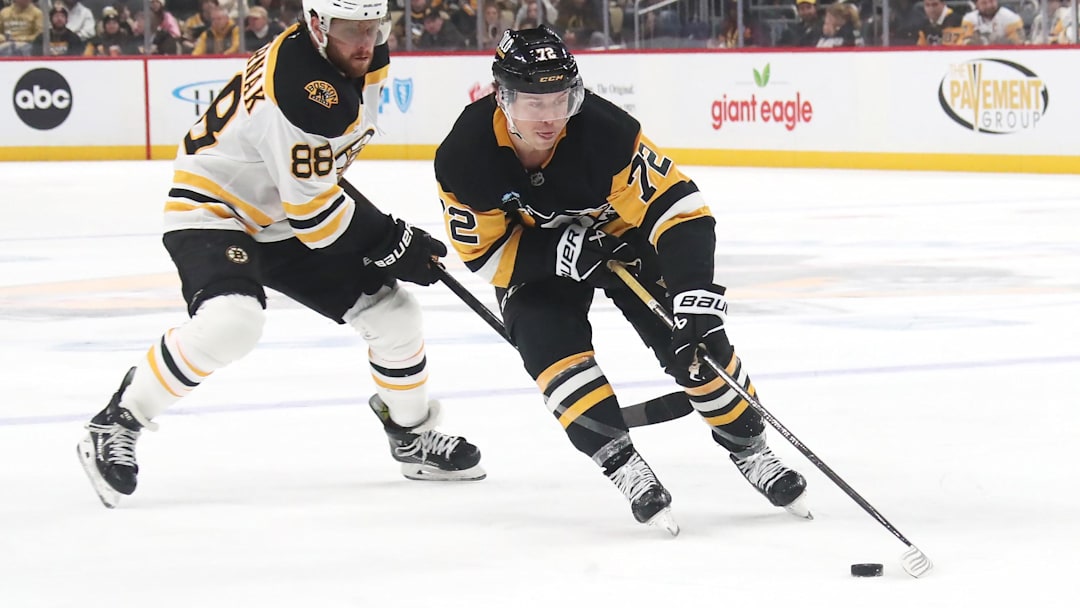 Mar 1, 2025; Pittsburgh, Pennsylvania, USA;  Pittsburgh Penguins left wing Anthony Beauvillier (72) moves the puck against Boston Bruins right wing David Pastrnak (88) during the third period at PPG Paints Arena. Mandatory Credit: Charles LeClaire-Imagn Images