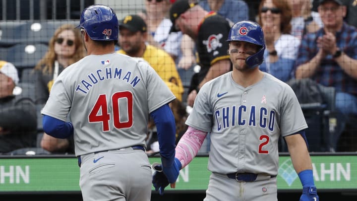 May 12, 2024; Pittsburgh, Pennsylvania, USA;  Chicago Cubs second baseman Nico Hoerner (2) greets right fielder Mike Tauchman (40) crossing home plate on a passed ball to score a run during the tenth inning at PNC Park. The Cubs won 5-4 in ten innings.