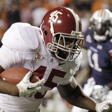 Nov 26, 2011; Auburn, AL, USA; Alabama Crimson Tide running back Jalston Fowler (45) pushes Auburn Tigers linebacker Jawara White (38) out of the way and scores a touchdown in the fourth quarter at Jordan-Hare Stadium.  The Crimson Tide beat the Tigers 42-14.  