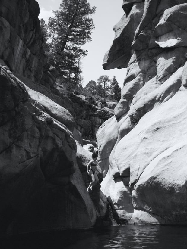 A swimmer enjoying a cliff jump into the water.