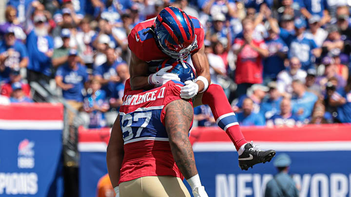 Sep 8, 2024; East Rutherford, New Jersey, USA; New York Giants defensive tackle Dexter Lawrence II (97) celebrates his sack with cornerback Nick McCloud (44) during the first quarter against the Minnesota Vikings at MetLife Stadium.  